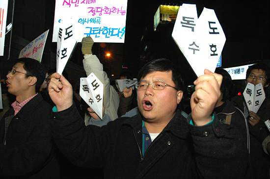 △참가자들이 독도수호라 적힌 종이비행기를 들고 "조례제정 반대한다"며 외치고 있다. 